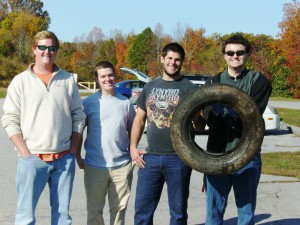 Students from BIOL 108 Environmental Biology proudly display a retrieved tire