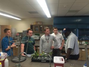 Dr. Laban Rutto, Virginia State University (right), visits Hampden-Sydney and provides Team Hops and Dakota Reinartz '18 (left) advice on their growth experiments.