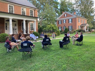 students sitting outdoors with masks on