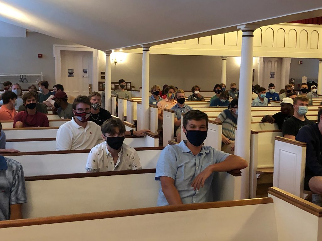 students in a church sanctuary with their masks on